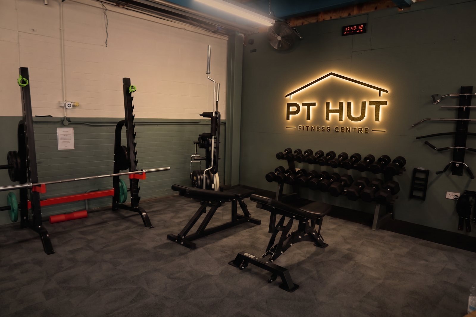 Free weights area with squat rack and dumbbells at The PT Hut